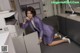 A woman in a purple suit sitting on the floor next to a printer.