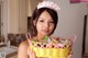 A woman holding a basket full of candy in a kitchen.