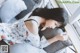 A woman laying on a bed with her head on a pillow.