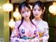 Two young women in kimonos standing next to each other.